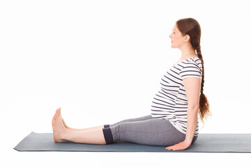 Pregnancy yoga exercise - pregnant woman doing yoga asana Dandasana Staff pose isolated on white background