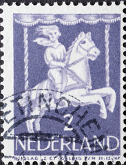 Netherlands - circa 1946: a postage stamp from the Netherlands , showing a Child in Merry-go-round. child postage stamp 1946 , blue