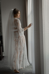 The bride in a gentle boudoir in a bright hotel room. Wedding day