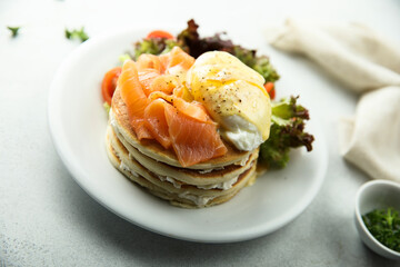 Homemade pancakes with poached egg and salmon