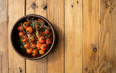Stock photo plate of cherry tomatoes in a rustic bowl on a wooden background. 