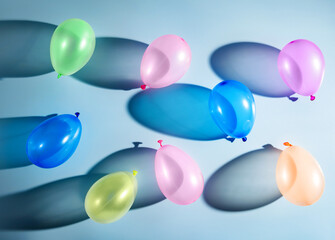 multi-colored balloons on a blue background with shadows.