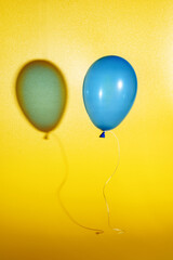 blue air balloon on a yellow background with a shadow.
