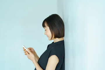 Naklejka premium スマートフォンを手にする女性