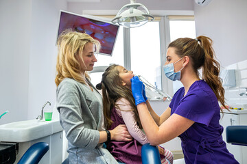 Little girl with her mom on visit their pediatric dentist