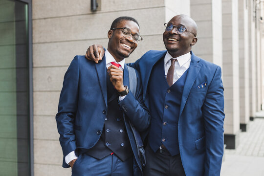 Portrait of two black African American businessman in suits outdoors. The joy of meeting good friends