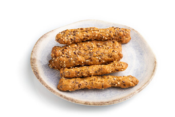 Crumble cookies with seasme and almonds on ceramic plate isolated on white background. side view, close up.