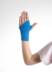 Blue elastic bandage on the arm of the child. White background, close-up