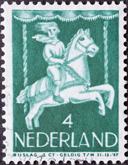 Netherlands - circa 1946: a postage stamp from the Netherlands , showing a Child in Merry-go-round. child postage stamp 1946 , green