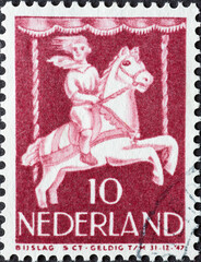 Netherlands - circa 1946: a postage stamp from the Netherlands , showing a Child in Merry-go-round. child postage stamp 1946 , brown