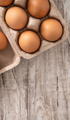 Fresh brown chicken eggs in a kraft paper egg carton.
