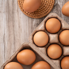 Fresh brown chicken eggs in a kraft paper egg carton.