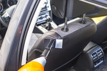 Cleaning a modern car interior with a vacuum cleaner from dirt and dust, background. Equipment