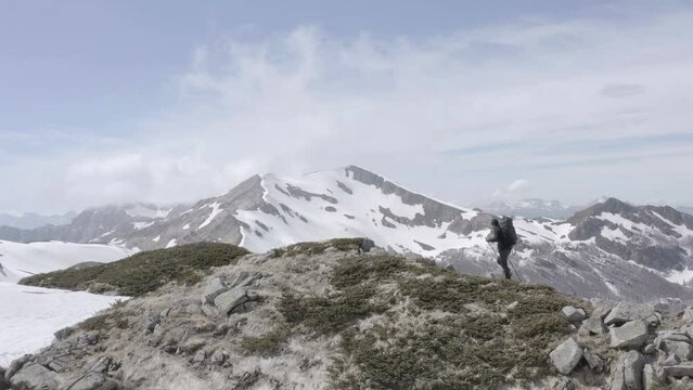 Adventurous hiker walking on impervious mountains in unexplored land