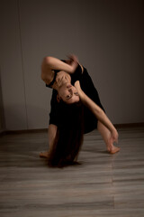 Fototapeta na wymiar Slender flexible dance performer during a dance practice in modern studio