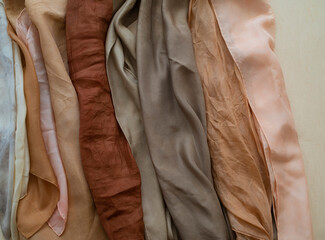 hand dyed clothes in warm natural tones on a bright background - text space -
slow fashion concept 