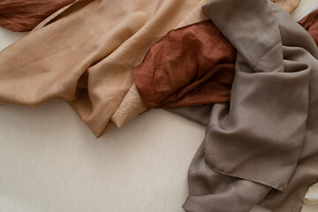 hand dyed clothes in warm natural tones hanging on a bright background - text space -
slow fashion concept 