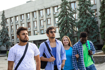 The diverse students leave the university after finish lessons