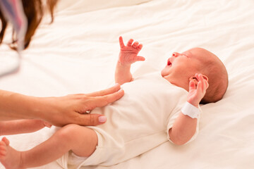 Mother is doing belly massage for newborn