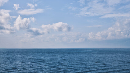 Obraz premium blue sea and fluffy clouds
