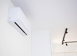 Modern wall-mounted air conditioner in the apartment with heating and cooling capacity of the room....