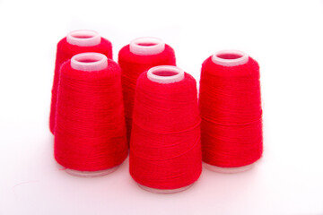 Red spool of thread isolated on white background. Skein of woolen threads. Yarn for knitting. Materials for sewing machine. Coil