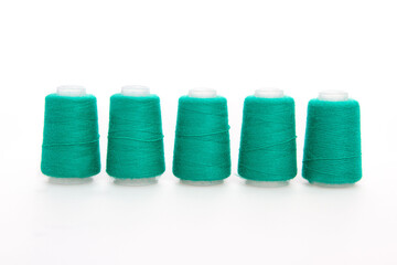 Green spool of thread isolated on white background. Skein of woolen threads. Yarn for knitting. Materials for sewing machine. Coil
