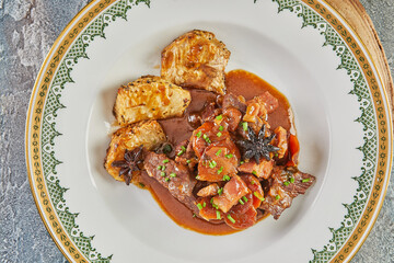 Beef casserole in beer on board on wooden stand