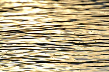 Golden ocean water, photo background. Beautiful summer sea, sunset time. Ocean surface natural background. Backdrop for lettering, cards, banner, design and decor elements. 