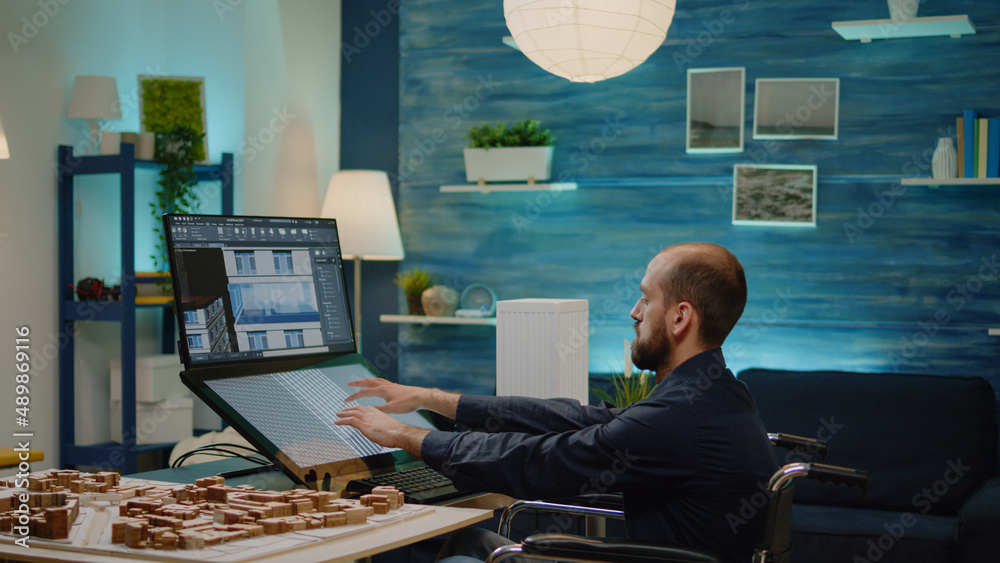 Poster disabled man working as architect with building model on touch screen monitor at office. engineer si