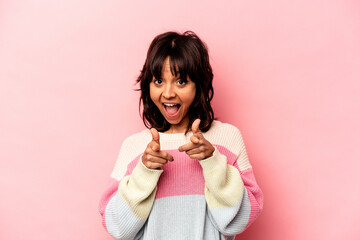 Young hispanic woman isolated on pink background cheerful smiles pointing to front.