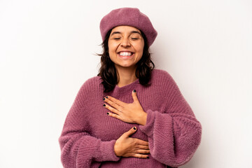 Young hispanic woman isolated on white background laughs happily and has fun keeping hands on stomach.