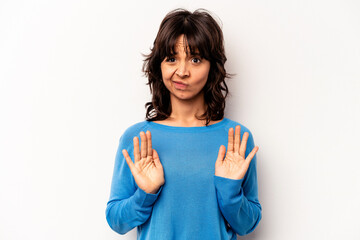 Young hispanic woman isolated on white background rejecting someone showing a gesture of disgust.