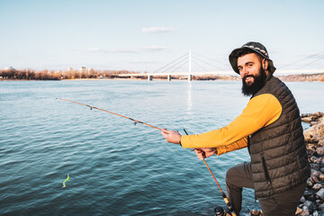 Man enjoys fishing by a river.
