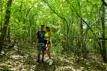 Fototapeta premium A man with a girl in the forest near the cave town of Tepe-Kermen Crimea Russia 2021