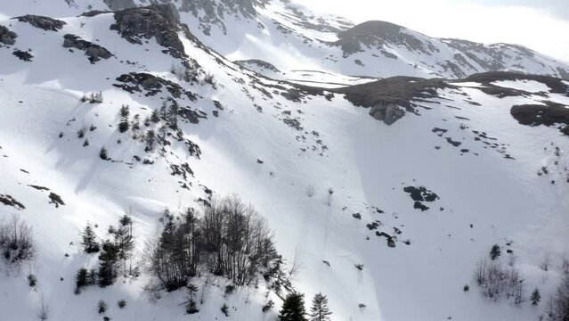 Aerial view flyight above beautiful remote mountain wilderness covered in snow