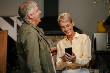 Caucasian senior couple laughing standing in kitchen