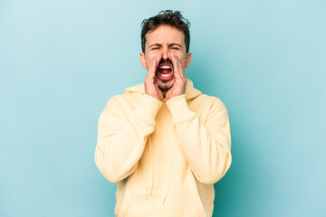Fototapeta premium Young caucasian man isolated on blue background shouting excited to front.