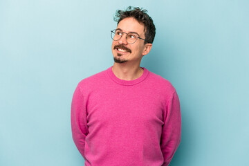 Young caucasian man isolated on blue background relaxed and happy laughing, neck stretched showing teeth.