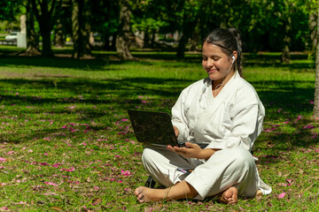 una mujer de arte marciales entrenando karate cinta negra haciendo reunion online en computadora