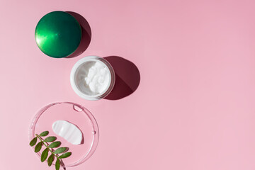 Skincare cosmetic cream or lotion swatch smear smudge on pink color background. White creamy hygiene beauty product in a jar. flat lay, copy space