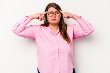 Obraz na płótnie Canvas Young caucasian overweight woman isolated on white background focused on a task, keeping forefingers pointing head.