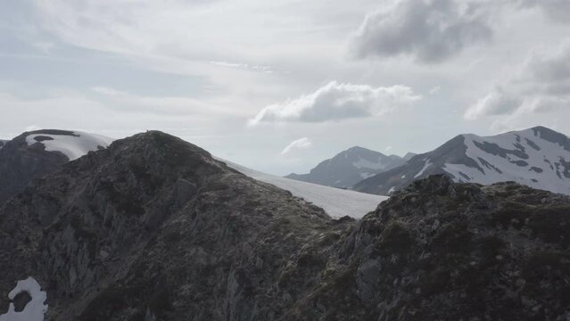 Aerial flight on mountain range flying above ridge covered in snow