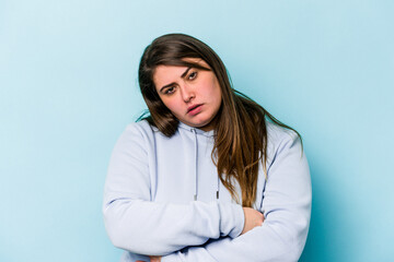 Young caucasian overweight woman isolated on blue background who is bored, fatigued and need a relax day.