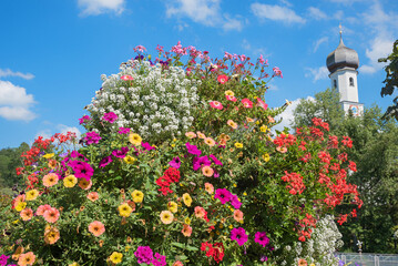 flower column with petunias and alyssum, against blue sky. tourist resort Gmund