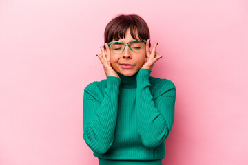 Young hispanic woman isolated on pink background touching temples and having headache.