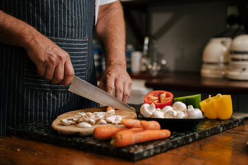 Caucasian senior male cooking dinner for wife 