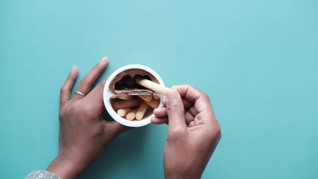 eating breadstick with chocolate spread cream top down 