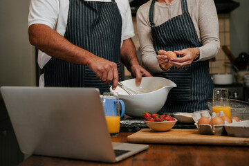 Fototapeta na wymiar Close up caucasian mature couple baking in kitchen together