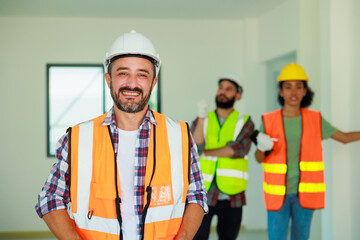 Portrait happy hispanic Construction Worker in safety hard hat helmet working on Building Site.